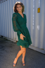 Modell danser i Grønn blondekjole med v-hals og lange ermer. Kne-lengde, selskapskjole eller hverdag.
