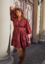 modell ute med Rød/burgunder kjole med puffede ermer, knapper og volanger – perfekt som festkjole, cocktailkjole eller til pen hverdagsbruk